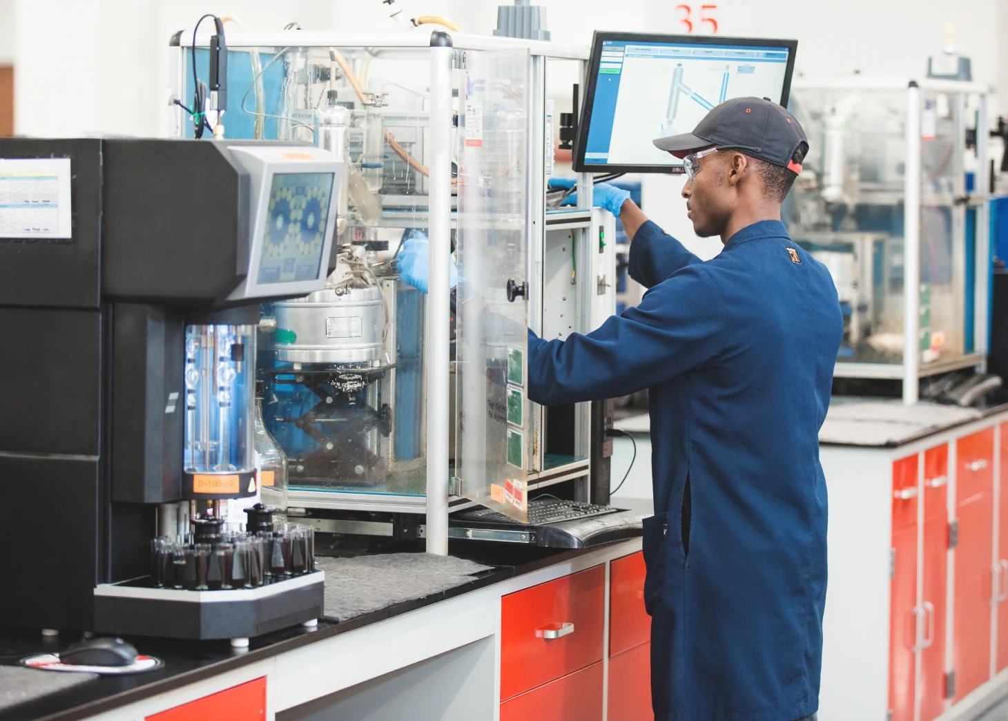 A man in a laboratory stands in front of a machine, performing an analysis.