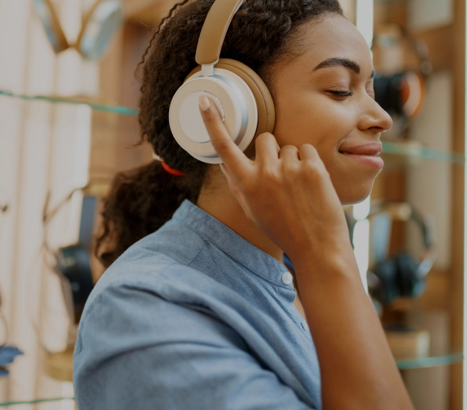 Woman wearing headphones with her eyes closed and smiling.